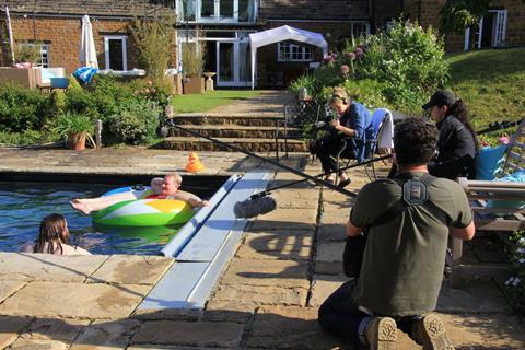 Jed and Victoria in outdoor swimming pool with crew